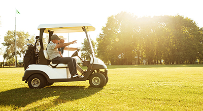 Two men riding in a golf cart